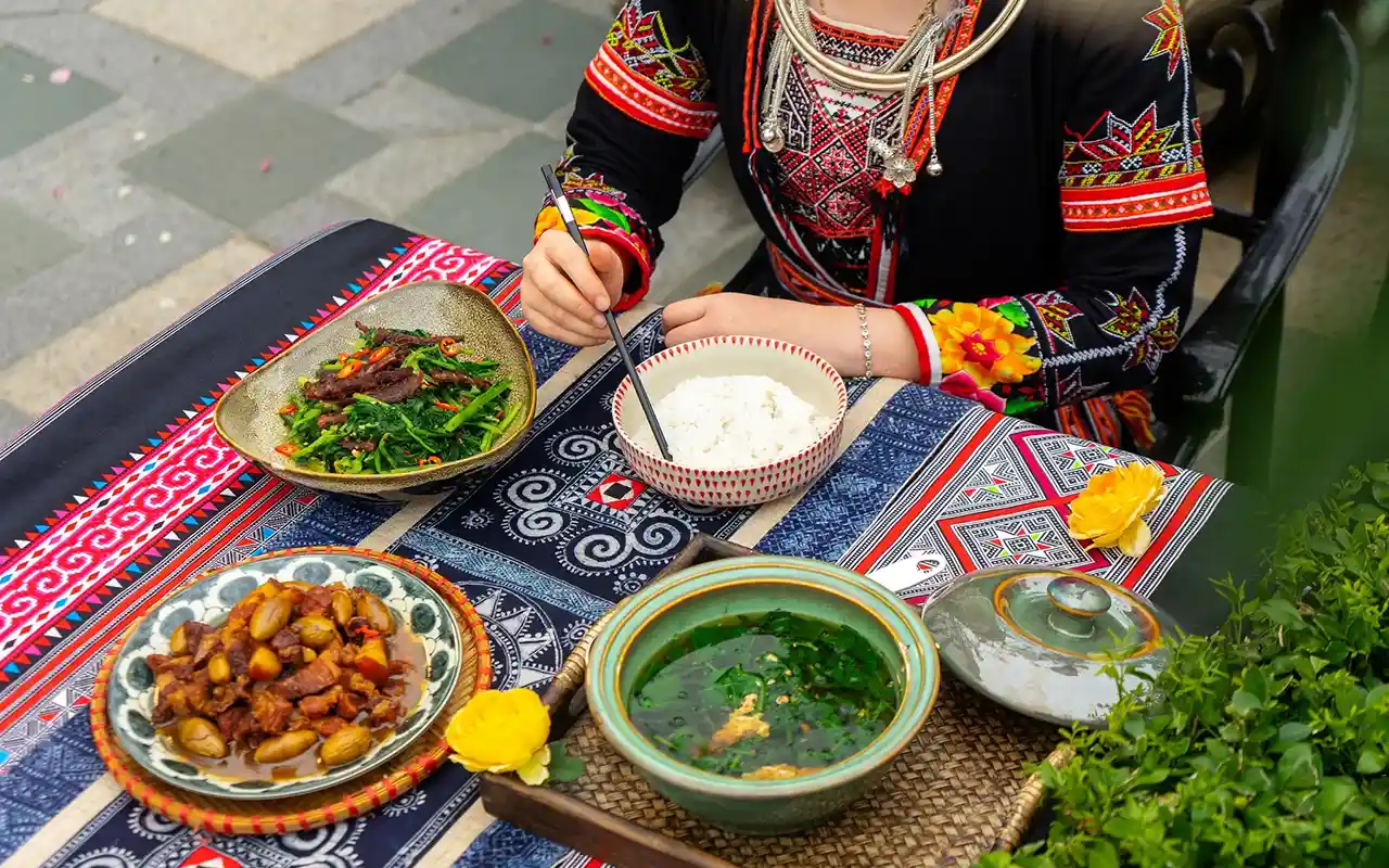 Person in traditional attire eating colorful meal